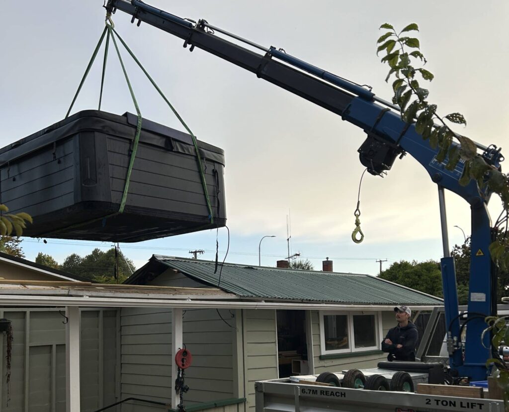 Spa Pool movers moving spa pool into place with hiab in Hamilton