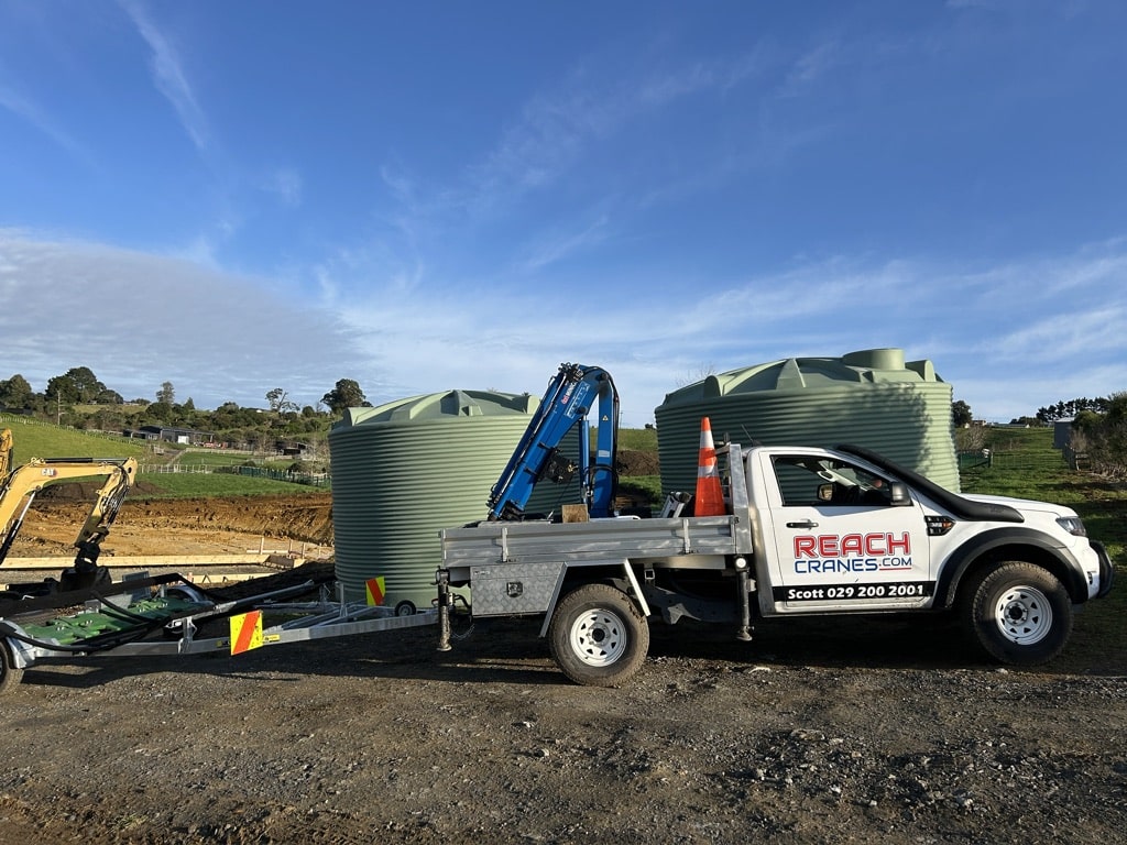 The Reach Cranes mini Hiab on site after delivering and positioning two 30,000L water tanks in Hamilton.
