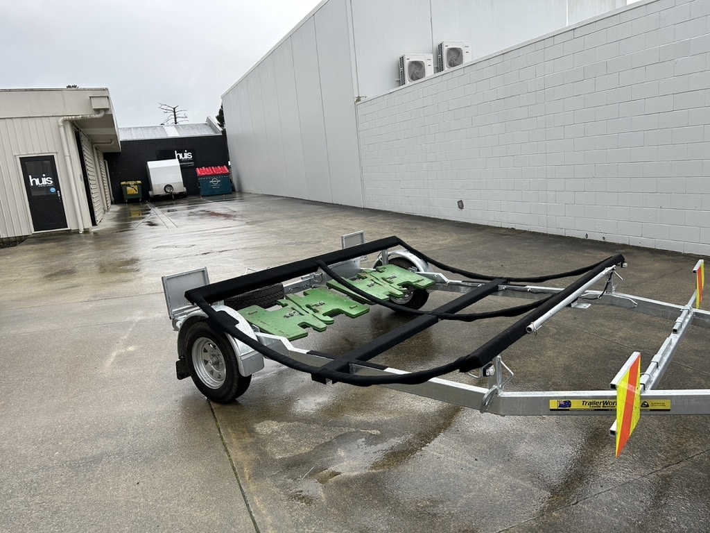The Reach Cranes’ custom trailer with carpeted scallop cradle supporting a 30,000L water tank before loading.