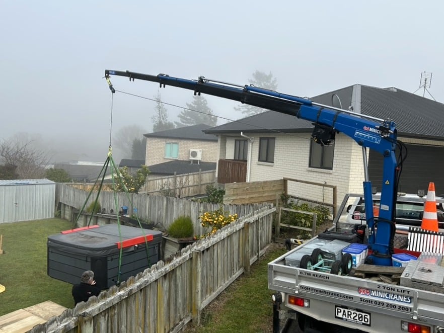 spa pool being lifted into backyard